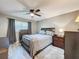 Serene bedroom with gray bedding, ceiling fan, and a dresser with coordinated decor at 11722 Carissa Ln # 49A, New Port Richey, FL 34654