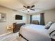 Cozy bedroom with neutral gray bedding, ceiling fan, and a Tampa Bay Buccaneers themed decor at 11722 Carissa Ln # 49A, New Port Richey, FL 34654