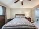 Relaxing bedroom with gray bedding, ceiling fan, dresser, and 