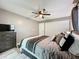 Comfortable bedroom featuring a ceiling fan, modern gray and white bedding and stylish gray dresser at 11722 Carissa Ln # 49A, New Port Richey, FL 34654