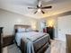 Well-lit bedroom with gray bedding, dark wood furniture and decor, and a walk-in closet at 11722 Carissa Ln # 49A, New Port Richey, FL 34654