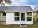 Exterior view of a home featuring a sunroom with white trim and a metal roof, showcasing a cozy and inviting space at 11722 Carissa Ln # 49A, New Port Richey, FL 34654