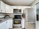 Stylish kitchen featuring stainless steel appliances, white cabinets, and modern accents at 11722 Carissa Ln # 49A, New Port Richey, FL 34654