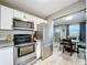 Open kitchen adjacent dining area showcasing stainless steel appliances and subway tile at 11722 Carissa Ln # 49A, New Port Richey, FL 34654