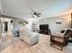 Comfortable living room with a ceiling fan, neutral walls, wood floors, and a large television for entertainment at 11722 Carissa Ln # 49A, New Port Richey, FL 34654