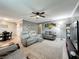 Open-concept living room with a ceiling fan, neutral paint, and wood floors, and a comfortable seating arrangement at 11722 Carissa Ln # 49A, New Port Richey, FL 34654