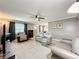 Bright living room with a ceiling fan, neutral decor, wood floors, and a comfortable seating area for relaxation at 11722 Carissa Ln # 49A, New Port Richey, FL 34654