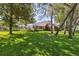 Beautiful backyard with a screened-in pool, surrounded by trees and a well-maintained lawn at 12295 Clarendon Ct, Spring Hill, FL 34609