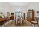 Elegant dining room with a grand chandelier, large windows, and hardwood furniture, ideal for formal gatherings at 12295 Clarendon Ct, Spring Hill, FL 34609
