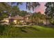 Inviting exterior with a well-manicured lawn and lush landscaping surrounding the pink stucco and brick home at 12295 Clarendon Ct, Spring Hill, FL 34609