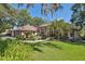 Inviting exterior with a well-manicured lawn and lush landscaping surrounding the pink stucco and brick home at 12295 Clarendon Ct, Spring Hill, FL 34609