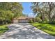 Charming home exterior with a manicured lawn, mature trees, and a spacious driveway at 12295 Clarendon Ct, Spring Hill, FL 34609