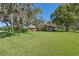 A lush green lawn and mature trees accent this large, single story house at 12295 Clarendon Ct, Spring Hill, FL 34609