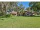 A lush green lawn and mature trees accent this large, single story house at 12295 Clarendon Ct, Spring Hill, FL 34609