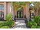 Charming entrance with double doors, mature landscaping, and decorative accents creating an inviting entryway at 12295 Clarendon Ct, Spring Hill, FL 34609
