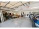 Spacious garage with an overhead door, storage shelves, and a blue car parked inside at 12295 Clarendon Ct, Spring Hill, FL 34609