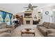 Comfortable living room with a stone fireplace, ceiling fan, and large windows, perfect for relaxing and entertaining at 12295 Clarendon Ct, Spring Hill, FL 34609