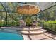 Comfortable rocking chairs sitting on the pool patio with steps leading to the refreshing pool at 12295 Clarendon Ct, Spring Hill, FL 34609