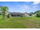 Expansive backyard featuring screened-in pool and lush landscaping at 13125 Jessica Dr, Spring Hill, FL 34609