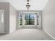 Elegant dining room with large window view, neutral walls, carpet, and chandelier lighting at 13125 Jessica Dr, Spring Hill, FL 34609