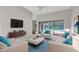 Stylish living room with neutral walls, plush seating, and a view of the screened pool at 13125 Jessica Dr, Spring Hill, FL 34609