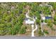 Aerial view of the property featuring a home, pool, multiple outbuildings, and wooded surroundings at 13345 Convent Garden Rd, Brooksville, FL 34613