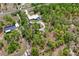 Aerial view displays the home, outbuildings, and lush surrounding nature at 13345 Convent Garden Rd, Brooksville, FL 34613