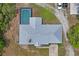 Aerial view of the home with a metal roof, a screened pool, and trees at 13345 Convent Garden Rd, Brooksville, FL 34613
