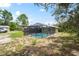 Backyard view of screened-in pool and home with a spacious outdoor area at 13345 Convent Garden Rd, Brooksville, FL 34613