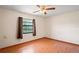 Empty bedroom with window, ceiling fan, and wood-look flooring at 13345 Convent Garden Rd, Brooksville, FL 34613