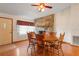 Dining room showcasing a stone fireplace, wood floors, ceiling fan and view into entryway at 13345 Convent Garden Rd, Brooksville, FL 34613