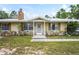 Close up on exterior showcasing the charming ranch-style home's entrance, stone accents, and well-kept lawn at 13345 Convent Garden Rd, Brooksville, FL 34613