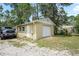 Exterior view of the detached garage with gravel driveway and landscaping at 13345 Convent Garden Rd, Brooksville, FL 34613