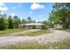 Charming ranch-style home featuring a metal roof, stone accents, and a detached garage with ample parking space at 13345 Convent Garden Rd, Brooksville, FL 34613