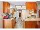Well-lit kitchen with wood cabinets, tile floors, and white appliances at 13345 Convent Garden Rd, Brooksville, FL 34613