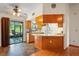 Bright kitchen with wood cabinets, tile floors, and sliding door access to the screened-in lanai at 13345 Convent Garden Rd, Brooksville, FL 34613