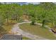 Expansive wooded lot with a long driveway and screened enclosure at one corner of the property at 13345 Convent Garden Rd, Brooksville, FL 34613