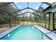 Inviting screened-in pool with clear blue water and surrounding lush greenery at 13345 Convent Garden Rd, Brooksville, FL 34613