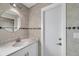 Bathroom with a round mirror, marble countertop and tile backsplash, and a white door at 13836 Darlene Ave, Hudson, FL 34667