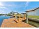 Waterfront property featuring a private boat dock and canal access on a sunny day with boats nearby at 13836 Darlene Ave, Hudson, FL 34667