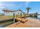 Waterfront property featuring a private boat dock and canal access on a sunny day with a Palm tree at 13836 Darlene Ave, Hudson, FL 34667