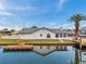 Waterfront home with private dock access, palm tree, neutral color, and canal view at 13836 Darlene Ave, Hudson, FL 34667