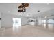 Open concept living room with sleek tile flooring and vaulted ceiling with a fan at 13836 Darlene Ave, Hudson, FL 34667