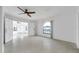 Spacious living room with neutral tile flooring, ceiling fan, and an arched window providing plenty of natural light at 13836 Darlene Ave, Hudson, FL 34667