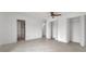Spacious main bedroom with neutral tile flooring, a ceiling fan, and double closets with louvered doors at 13836 Darlene Ave, Hudson, FL 34667