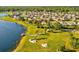 Aerial view of a lakeside community, showcasing the homes, park, lake, and walking paths at 14000 Lugano Ct, Hudson, FL 34669