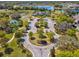 Stunning aerial view of community amenities, featuring a clubhouse, parking, and lake at 14000 Lugano Ct, Hudson, FL 34669