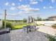 Backyard featuring stone patio, dining set, garden, and basketball hoop in a well-landscaped outdoor space at 14000 Lugano Ct, Hudson, FL 34669
