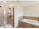 Modern bathroom with a glass-enclosed shower and soaking tub, designed for relaxation and comfort at 14000 Lugano Ct, Hudson, FL 34669