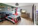 Comfortable bedroom featuring wood-look flooring, decorative shelves, and a mounted TV at 14000 Lugano Ct, Hudson, FL 34669